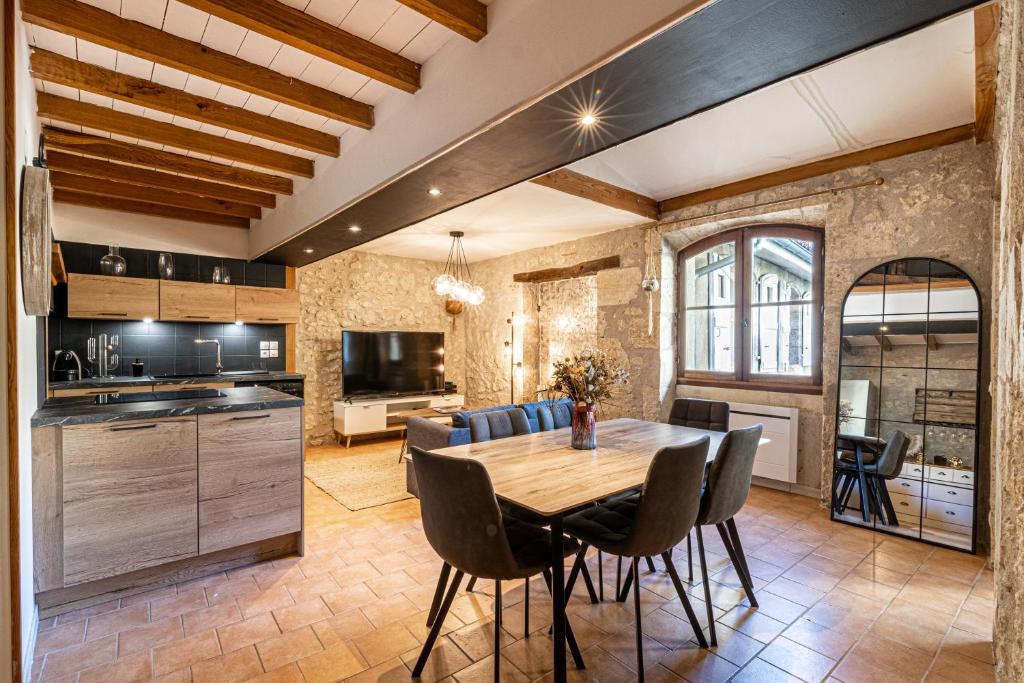 cocina y comedor con mesa de madera y sillas en Superbe appartement, situé au cœur de la ville., en Auch