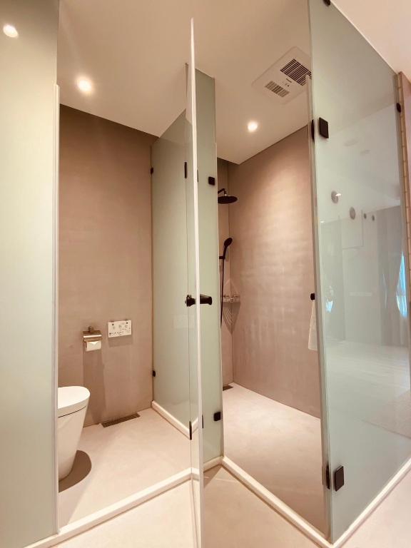 a bathroom with a toilet and a glass shower at Cingjing Florence Resort Villa in Ren&#39;ai
