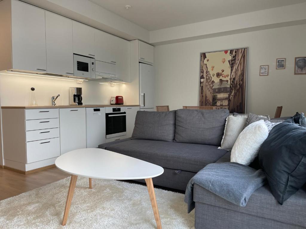 a living room with a couch and a table at Uusi kaksio Kaarinan keskustassa in Kaarina