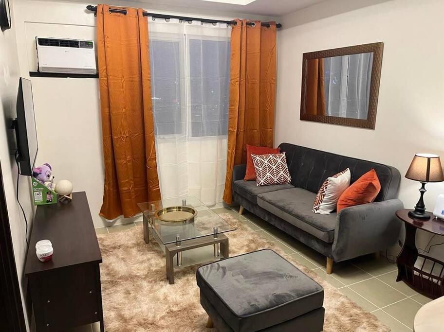 ein Wohnzimmer mit einem Sofa und einem Tisch in der Unterkunft The Journeyman Suite at Covent Garden Sta Mesa Manila in Manila
