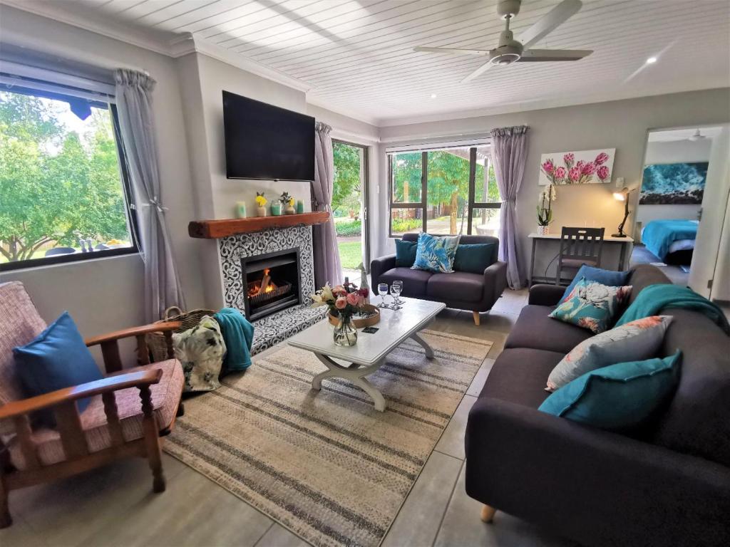 ein Wohnzimmer mit einem Sofa und einem Kamin in der Unterkunft The Bird Hide Luxury Self catering in White River