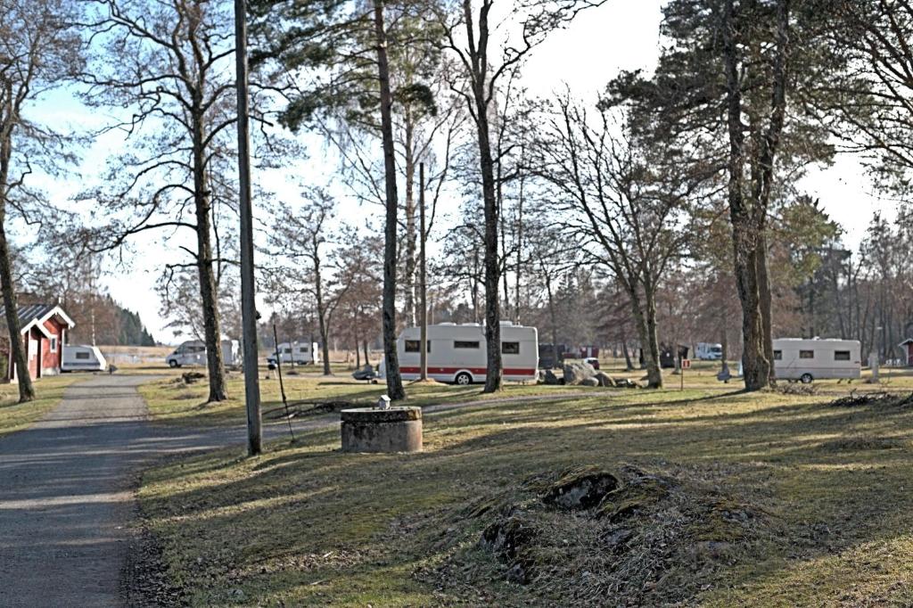 a park with two rvs and trees and a road at Pukinsaaren Camping in Kristiinankaupunki