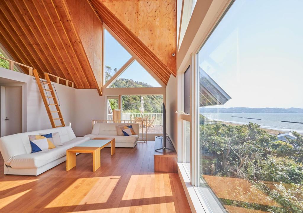 a living room with a white couch and a large window at 波の音テラス富津 in Futtsu