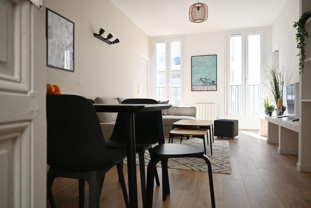 ein Wohnzimmer mit einem Esstisch und Stühlen in der Unterkunft Magnifique appartement T4, plage des Catalans in Marseille