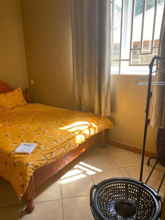 um pequeno quarto com uma cama e uma janela em Hein apartment em Arusha