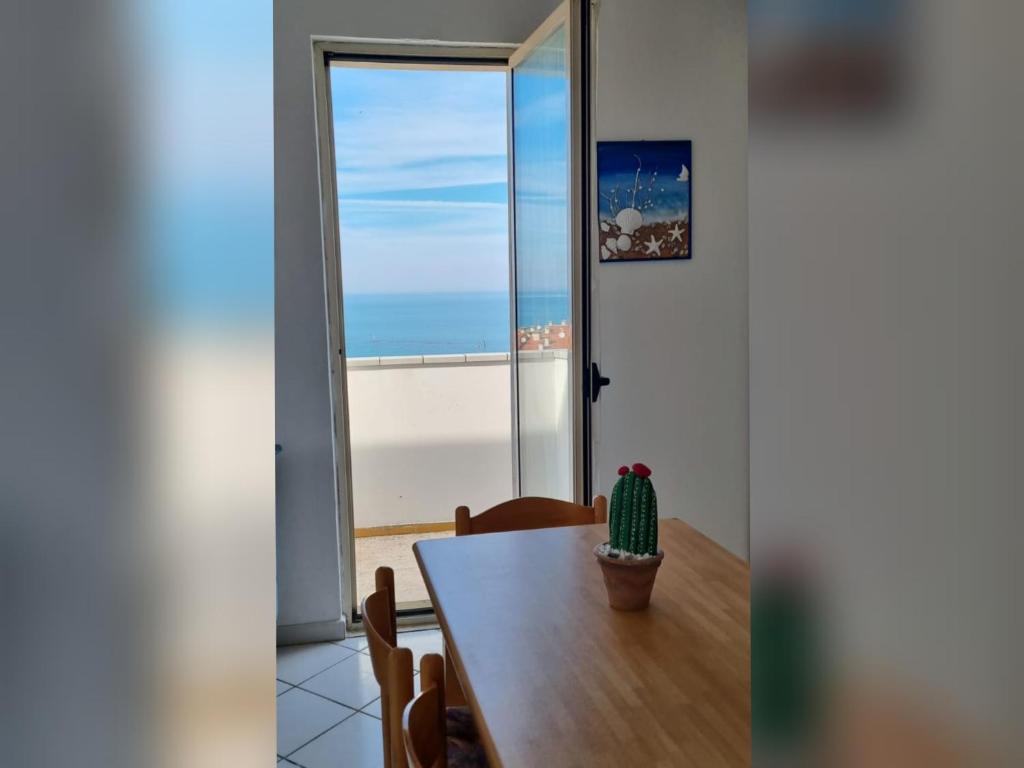 comedor con mesa y vistas al océano en Attico Blu Mare, en Porto Recanati