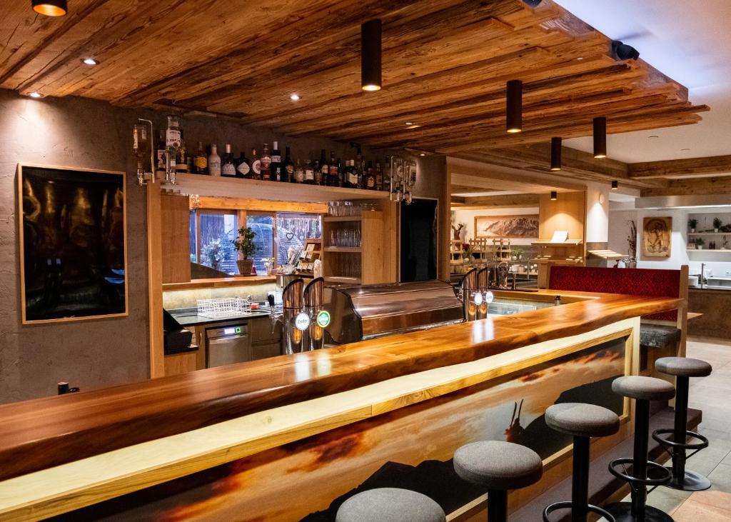 eine Bar mit einer Holztheke in einem Zimmer in der Unterkunft Hotel Lohningerhof in Maria Alm am Steinernen Meer