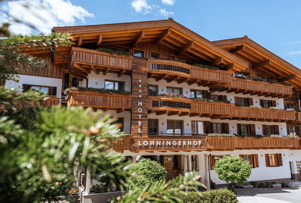a building with wooden balconies on top of it at Hotel Lohningerhof in Maria Alm am Steinernen Meer