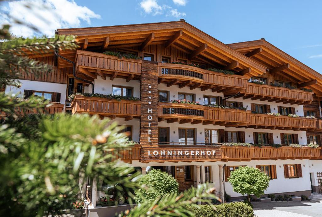 ein Gebäude mit Holzbalkonen darüber in der Unterkunft Hotel Lohningerhof in Maria Alm am Steinernen Meer