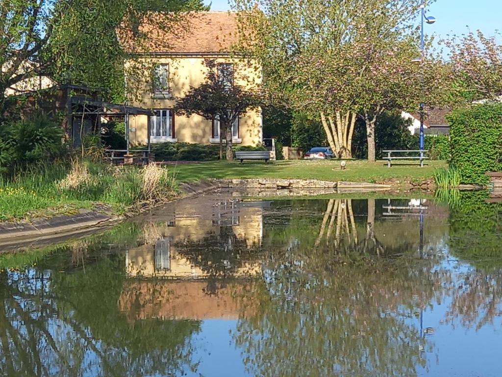 une maison et un étang en face d'une maison dans l'établissement Le gite du port 2 chambres, à Lere