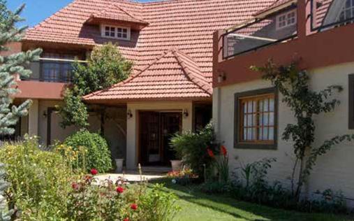 uma casa grande com telhado de azulejo em Hosteria Amparo em Neuquén