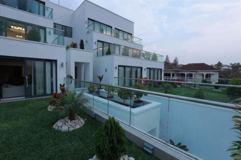 uma imagem de uma casa com piscina em White Stone Apartments Nyarutarama em Kigali