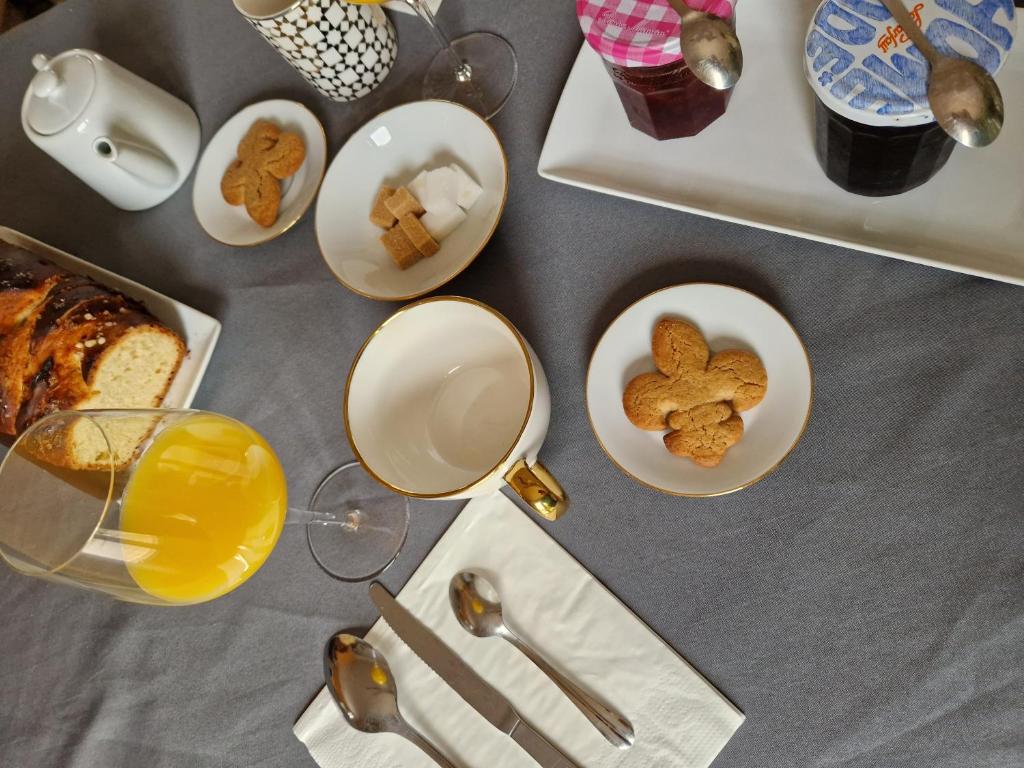 een tafel met borden en een glas sinaasappelsap bij La Parenthèse in Sambin