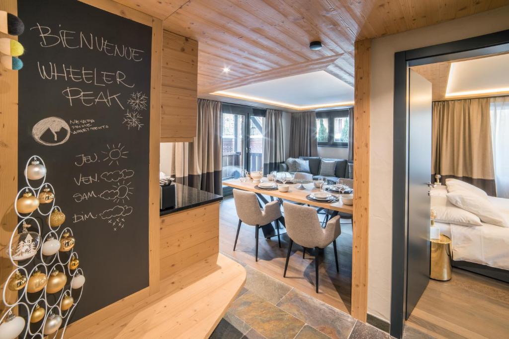 a dining room with a table with chairs and a room with at Luxury Chalets & Apartments by Mountain Exposure in Zermatt