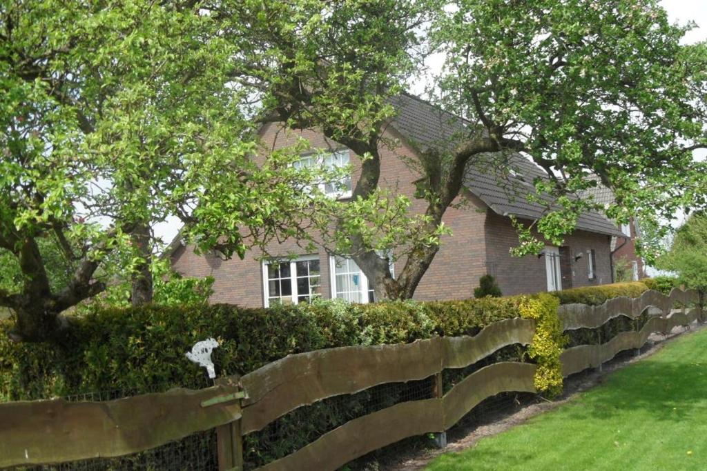 a brick house with a fence in front of it at Ferienwohnung Aurich Ostfriesland in Aurich