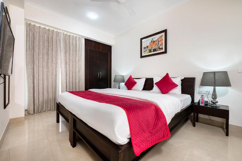 a bedroom with a large bed with red pillows at Palm Stay - Studios & Rooms in Jaipur