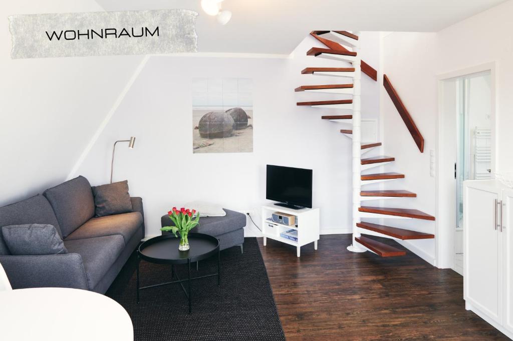 sala de estar con sofá y escalera de caracol en Ferienwohnung Maisonette in ruhiger und zentraler Lage mit Parkplatz, en Büsum
