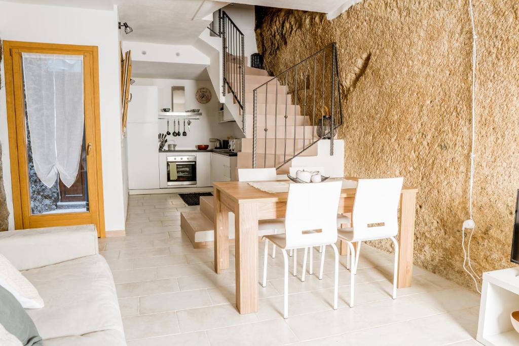 een keuken en eetkamer met een tafel en stoelen bij Sa Rocca in Bosa