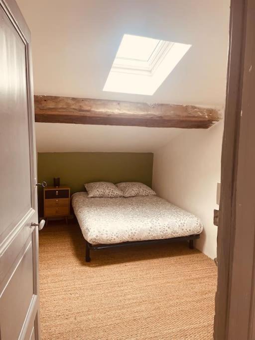 - une petite chambre avec un lit et une lucarne dans l'établissement Le 122, maison bastide St Louis Carcassonne, à Carcassonne