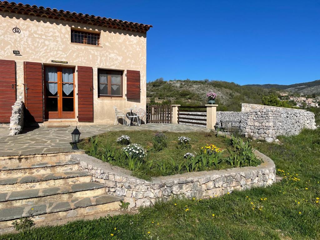 una casa con un jardín delante de ella en Le Castellaras - La Manonegra - Entre mer et montagne, endroit typique, nature, calme en Bézaudun-les-Alpes