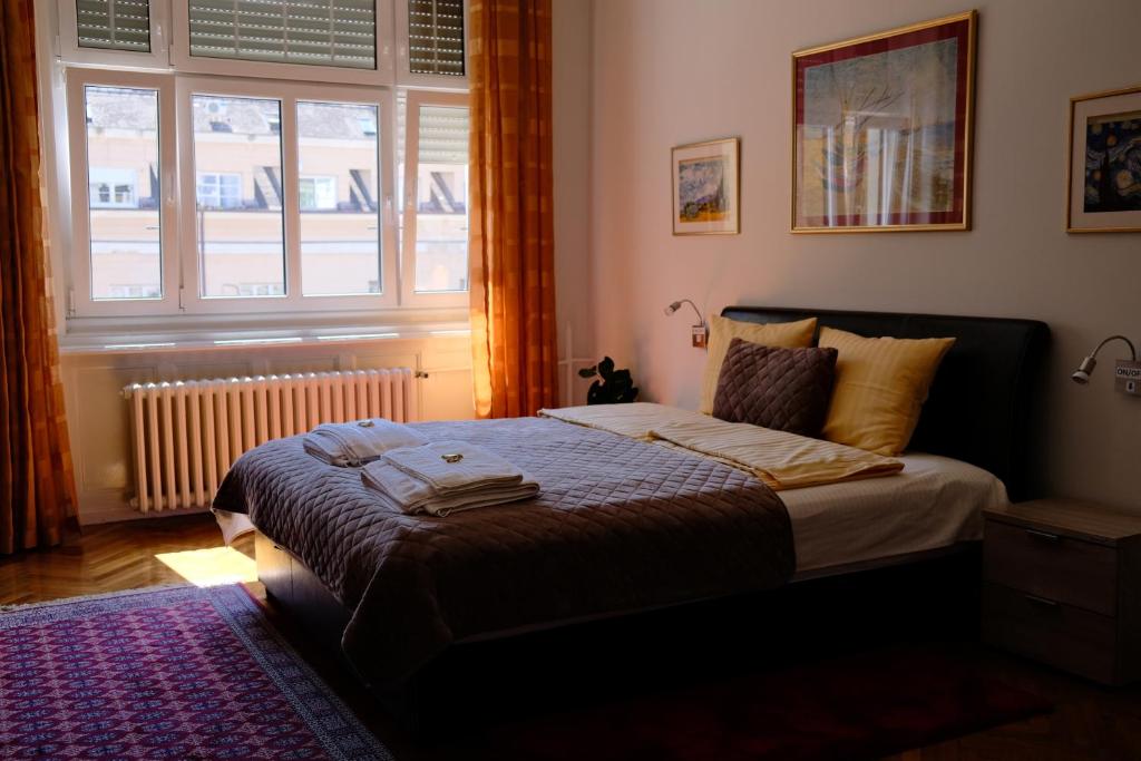 a bedroom with a large bed with a window at Apartment Centrum in Novi Sad