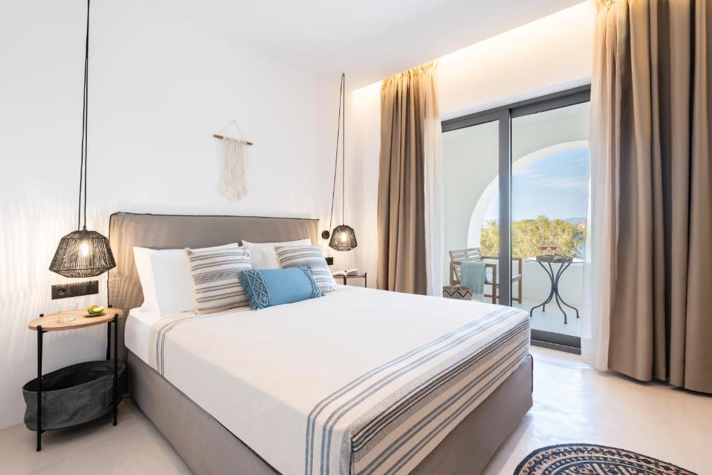 a bedroom with a large bed and a balcony at Eden Kythira in Diakofti