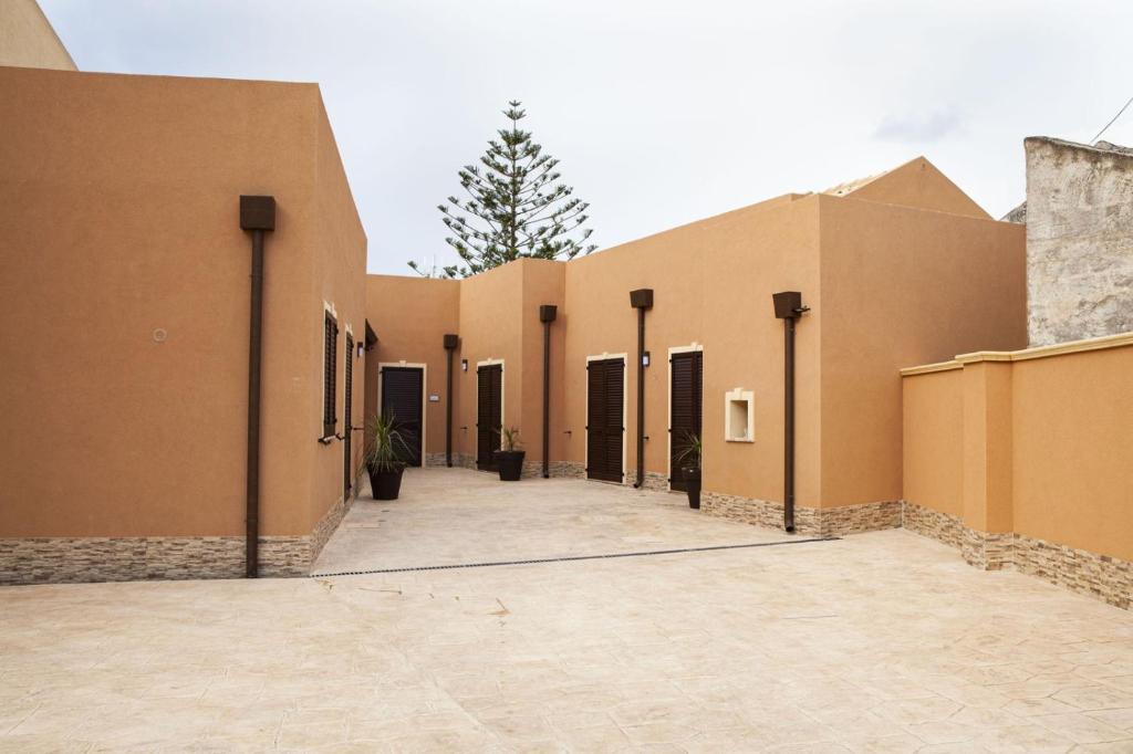 a building with a row of doors and a courtyard at casa vacanza zu ciano in Marausa