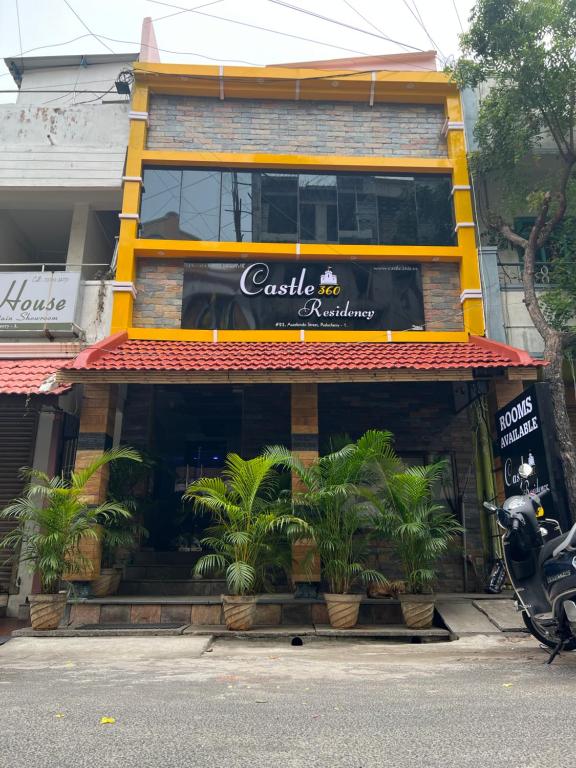 a restaurant with plants in front of a building at Castle 360 Residency in Pondicherry