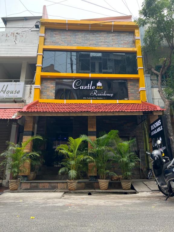 a restaurant with plants in front of a building at Castle 360 Residency in Puducherry