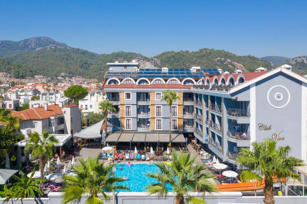 a hotel with a swimming pool and palm trees at Club Viva Hotel in Marmaris