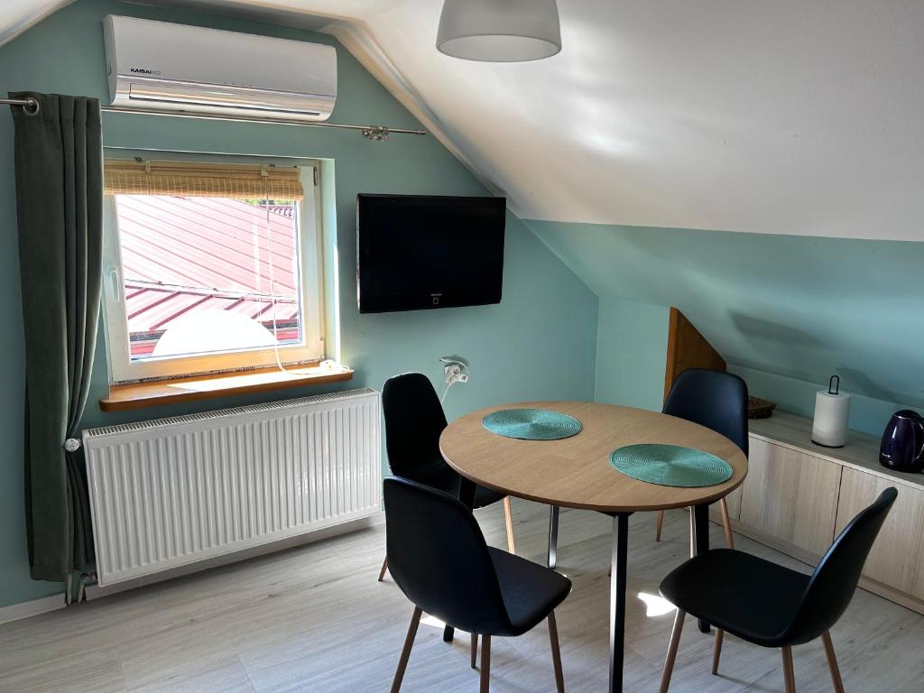 een kamer met een tafel en stoelen en een televisie bij Apartament Nad Suwalskim Bulwarem in Suwałki