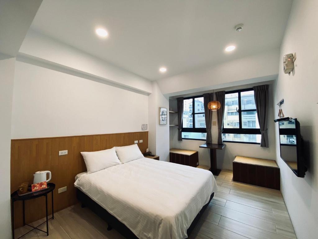 um quarto com uma cama e uma televisão em 良文旅 Ryou Hotel Tainan em Tainan