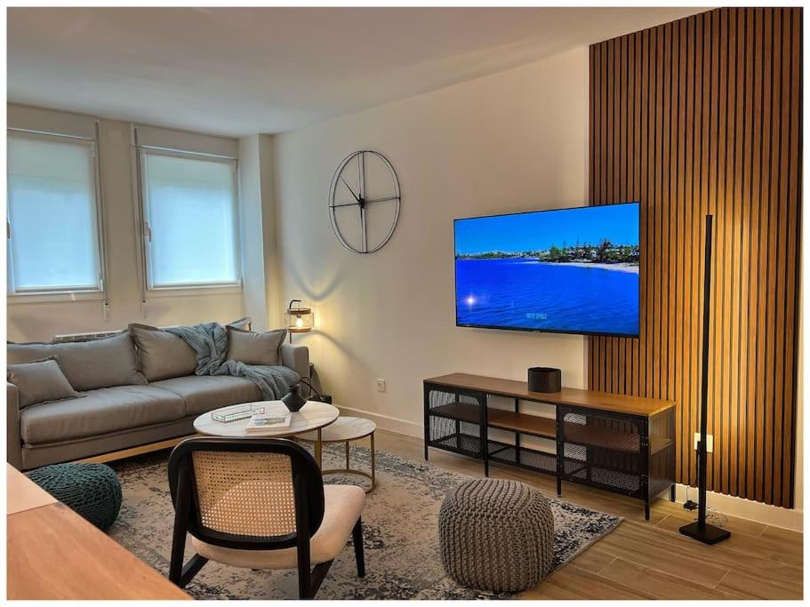 uma sala de estar com um sofá e uma televisão de ecrã plano em Elegance Lifestyle - Parking Gratuito! em San Sebastián