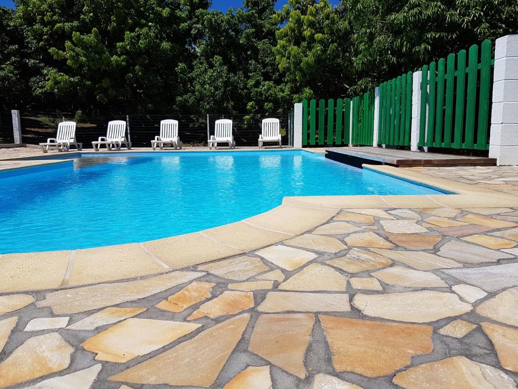 una piscina con sillas y una valla en Zoiseaux Paradis en Ravine des Cabris