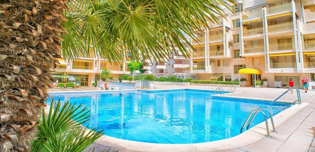 uma grande piscina em frente a um edifício em SALOU ,Novelty, primera línea del mar em Salou