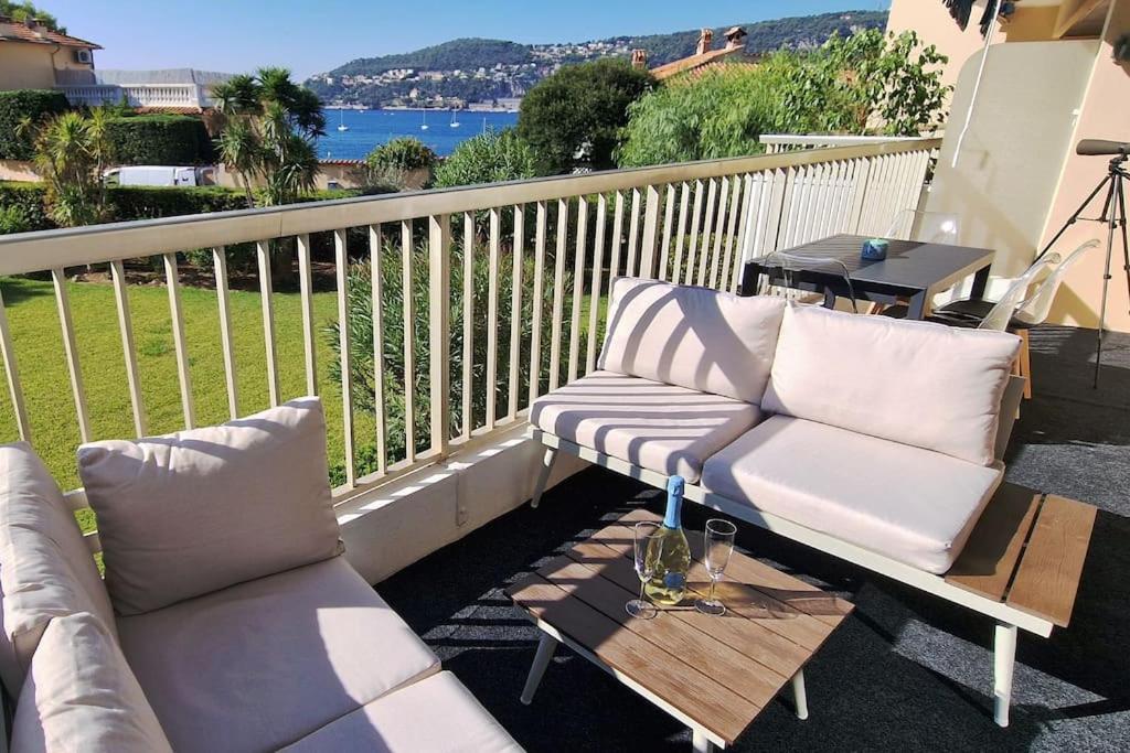 a balcony with two couches and a coffee table at La Suite de Saint-Jean-Cap-Ferrat, vue mer et accès mer in Saint-Jean-Cap-Ferrat