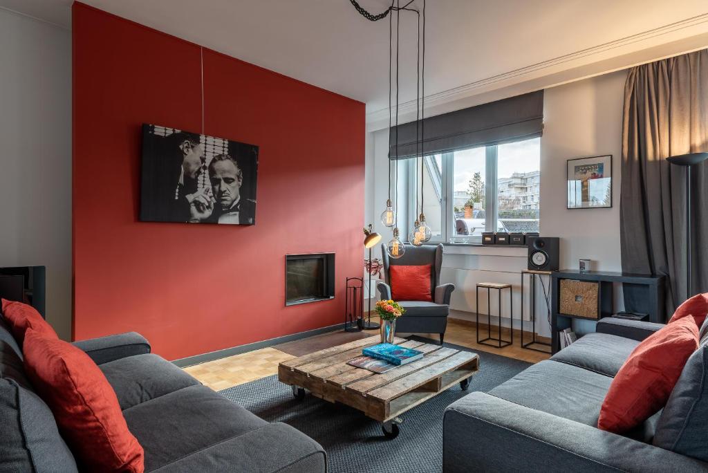 een woonkamer met 2 banken en een rode muur bij Woods Terrace residence in Brussel