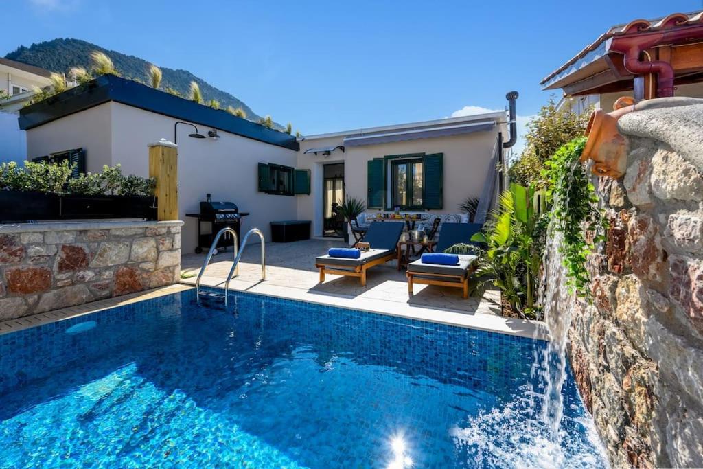 a swimming pool with a waterfall in a backyard at Moana House in Sálakos