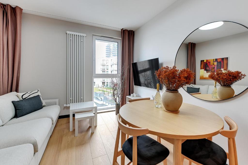 ein Wohnzimmer mit einem Tisch und einem Spiegel in der Unterkunft Luxury Aura 40 - 2 by Grand Apartments in Danzig