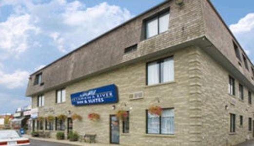 a large brick building with a blue sign on it at Petawawa River Inn & Suites in Petawawa