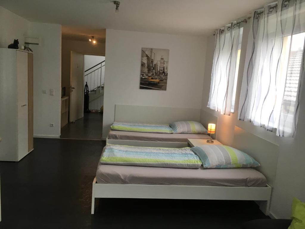 2 camas en una habitación con ventanas en Murthum Gästeappartments en Leinfelden-Echterdingen