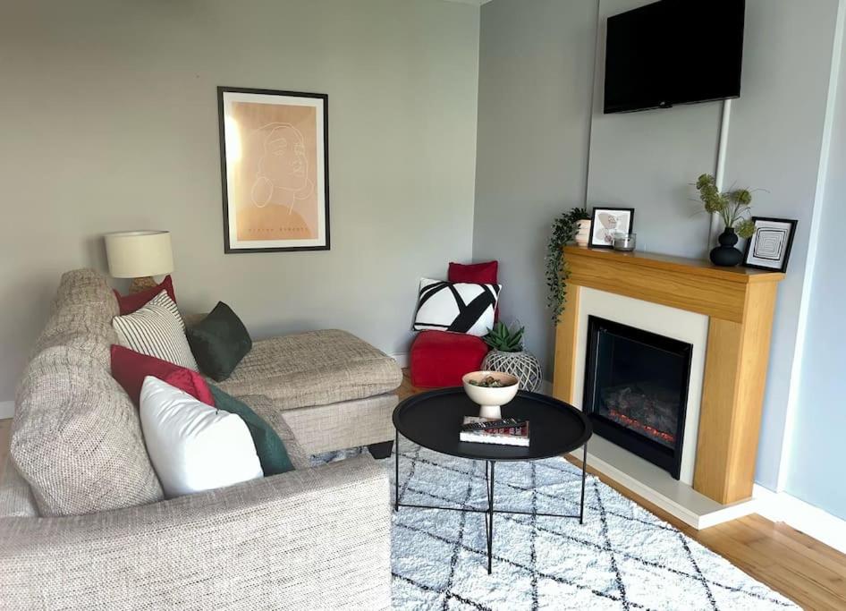 a living room with a couch and a fireplace at Villa in Youghal - Carleton Village in Youghal