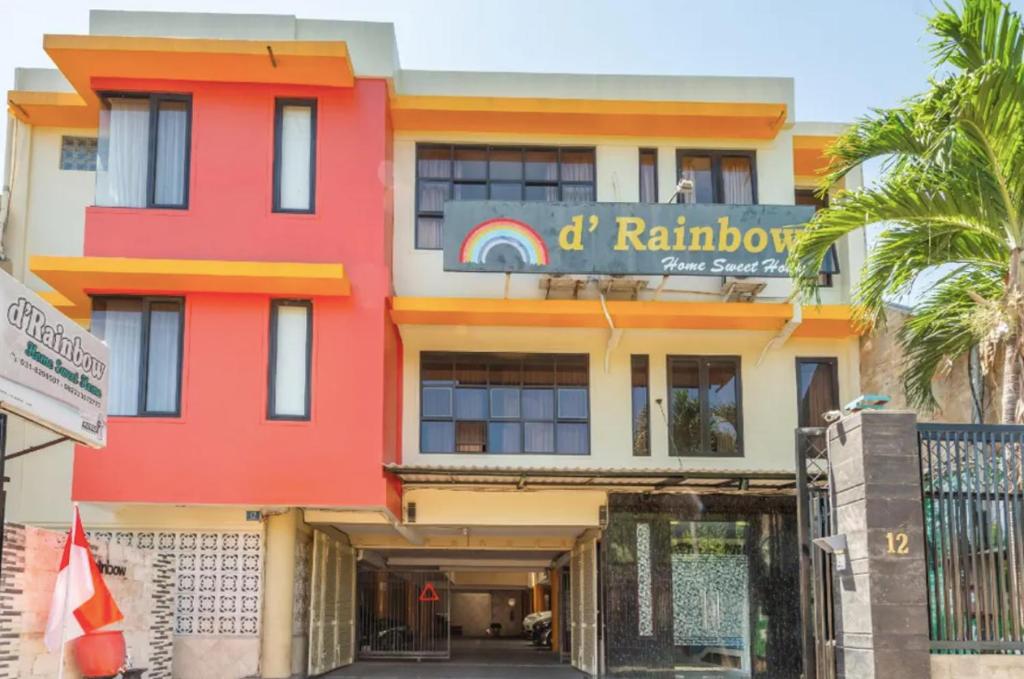 een kleurrijk gebouw met een regenboog bord erop bij TwoSpaces Living at D'Rainbow Homestay in Mergoredjo