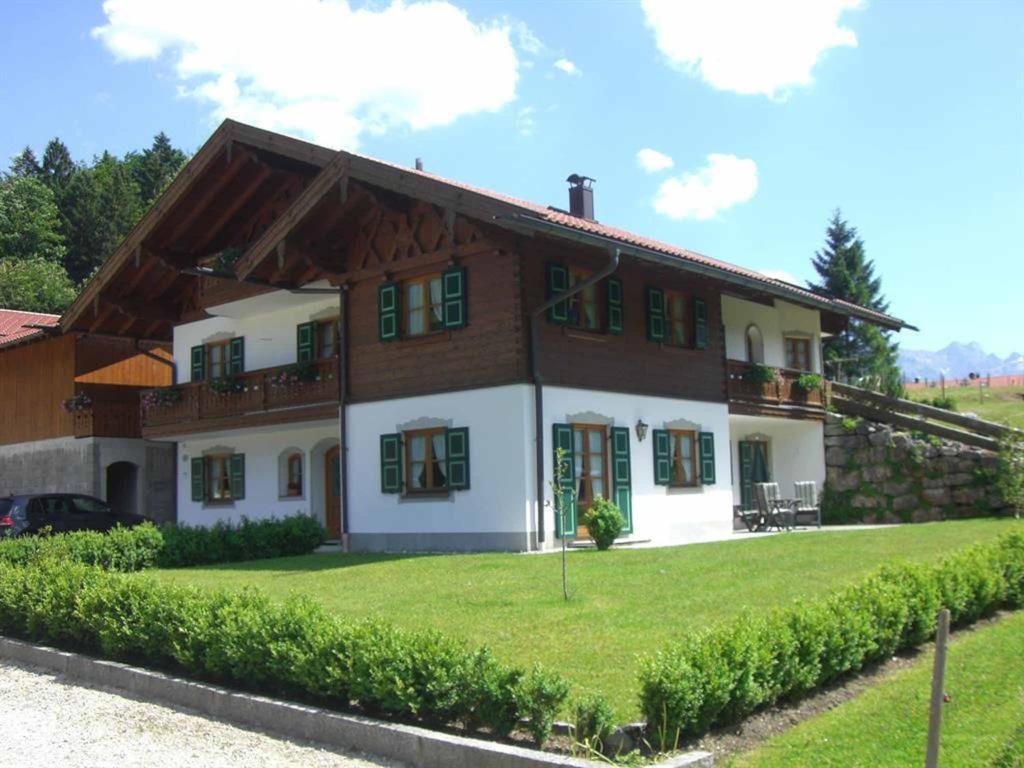 uma casa com um relvado verde em frente em Ferienwohnung Berghof em Wallgau