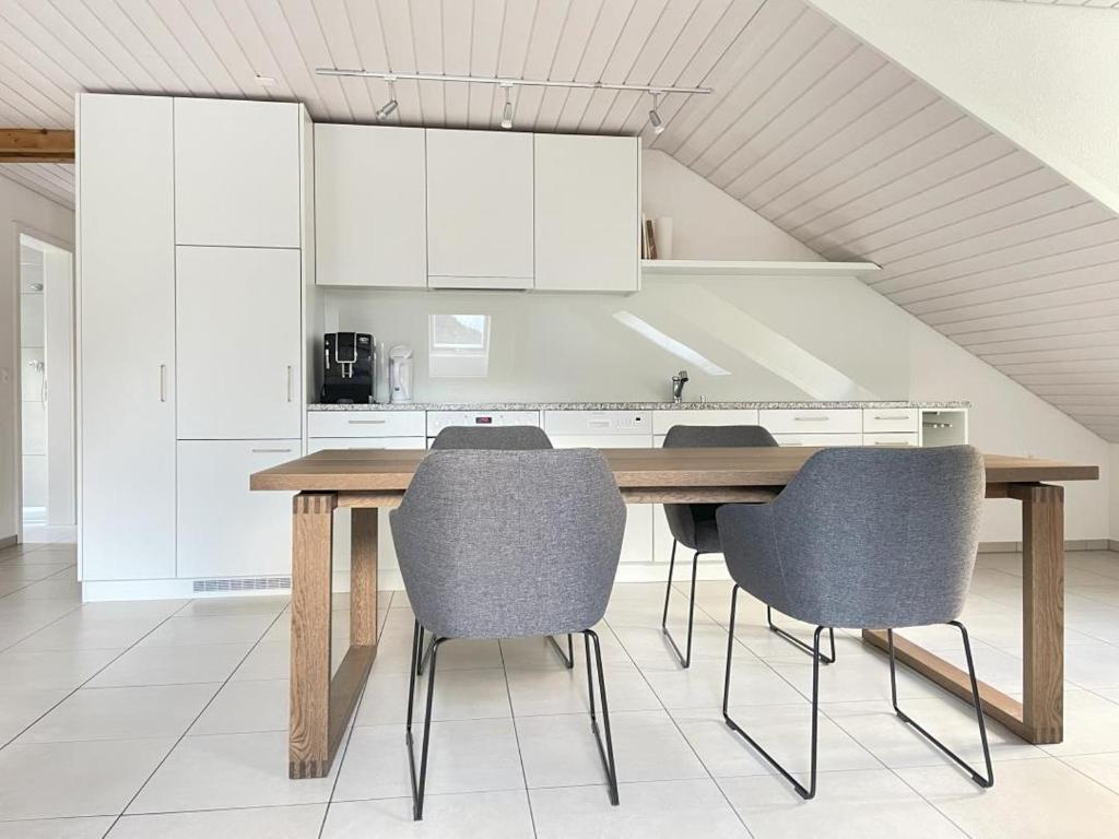 a kitchen with a wooden table and chairs at Revier Attika im Hazzo in Hätzingen