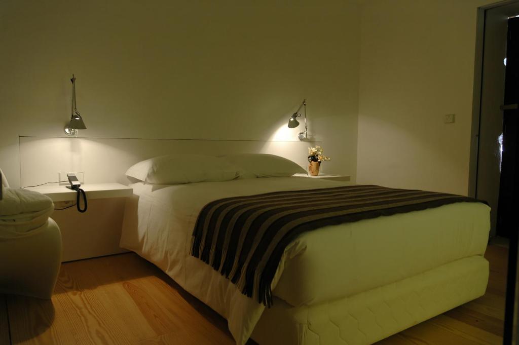 um quarto com uma cama grande com duas luzes em Convento de Tibaes em Braga
