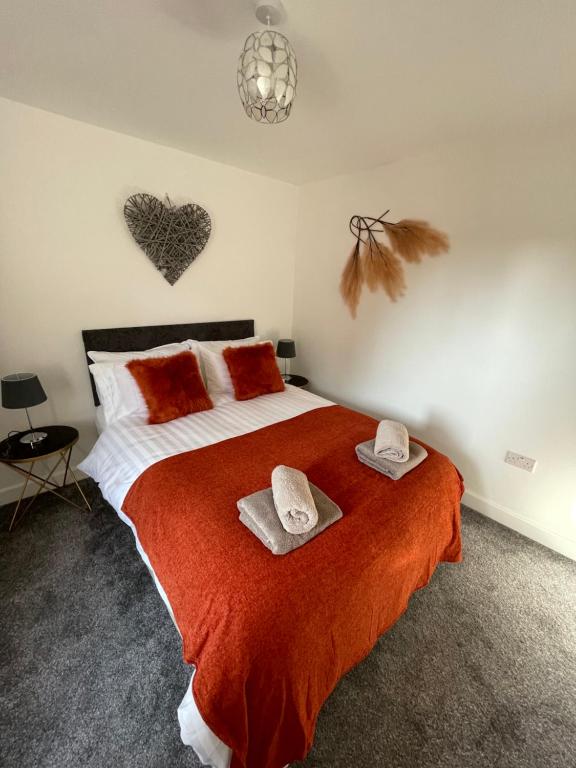 a bedroom with a bed with two towels on it at Luxury One Bed Apartment Stevenage in Stevenage