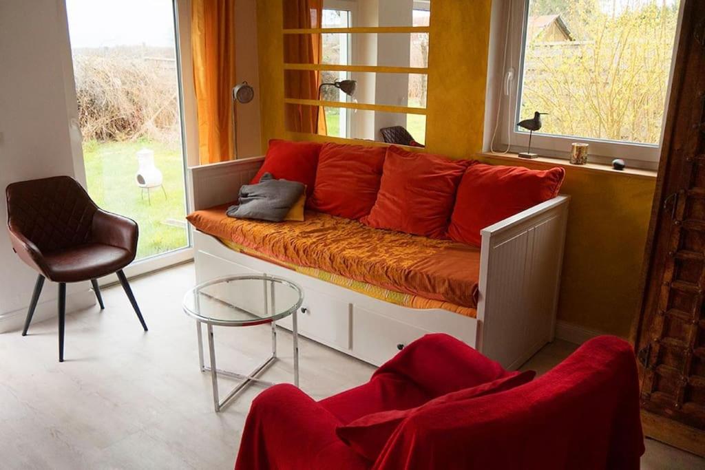 an orange couch in a room with a window at Haus Seenplatte in Groß Nemerow