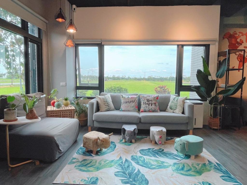 ein Wohnzimmer mit einem Sofa und einem großen Fenster in der Unterkunft 沐光森野旅宿 永續旅遊 in Wujie