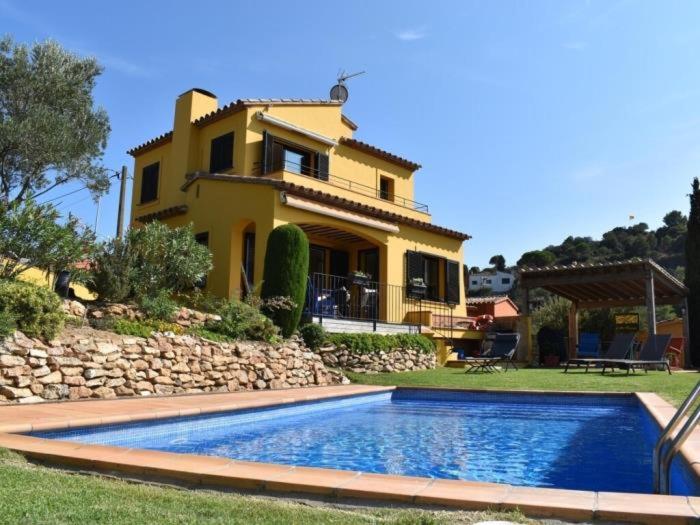 a house with a swimming pool in front of a house at Amaya in Begur
